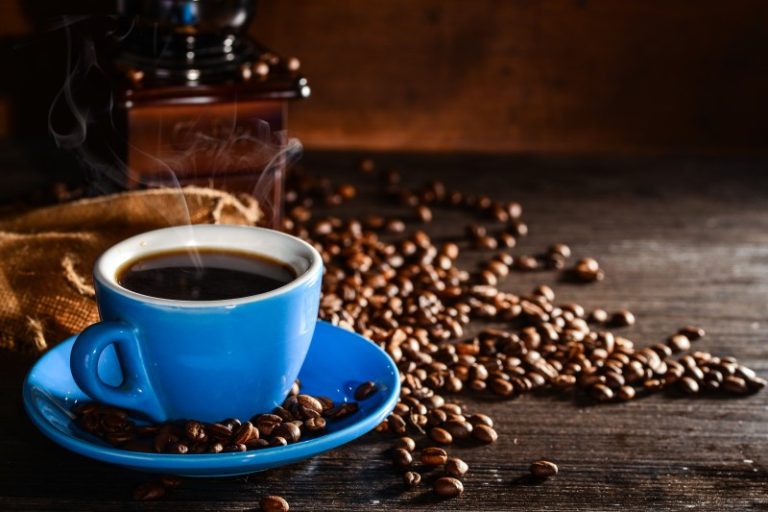 cup-coffee-with-coffee-beans-grinder-background